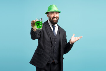 Elegant businessman with green hat toasting with green beer for St. Patrick's Day