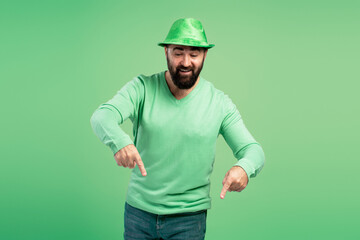 Bearded man with green hat pointing down celebrating St. Patrick's Day