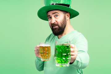Bearded Man Wearing Green Leprechaun Hat Holding Two Mugs of Beer for St. Patrick's Day