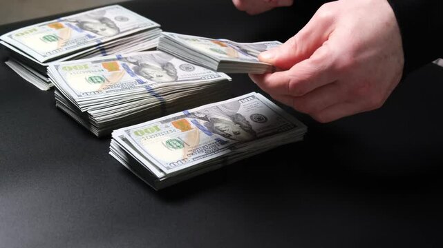 The man puts money in a large pile. The concept of frugality, saving, earning money