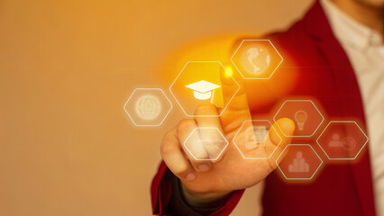 Man's hand touching digital graduation cap icon with educational icons

