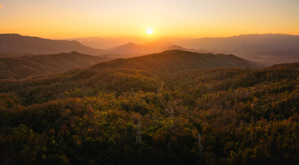 Mountain landscapes reveal scenic sunrises and sunsets painting the sky with clouds over forested hills and valleys