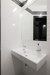 Faucet with ceramic sink and mirror in the bathroom