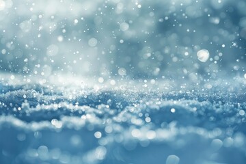 Snowy Winter blurry background in light blue silver tones Falling defocused snow with beautiful light.