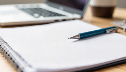 Close-up of blue pen resting on blank notepad, workspace inspiration
