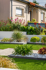 Charmant petit jardin paysagé avec ses fleurs et ses plantes vertes au printemps.