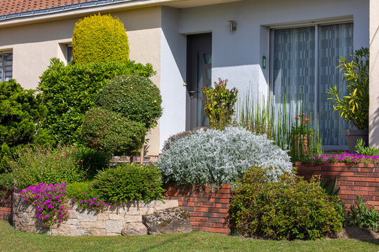 Charmant petit jardin paysag&eacute; avec ses fleurs et ses plantes vertes au printemps.