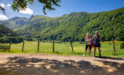 Randonneurs faisant une pose sur un chemin montagne au printemps dans le Cantal en France.