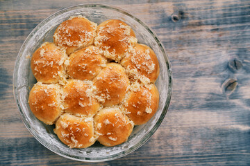 Buns with grated garlic lie on a dish on a wooden table