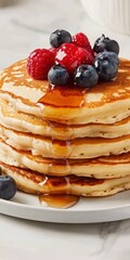 Close Up of Stacked Pancakes Topped with Berries and Drizzled with Syrup Sweet Treats Breakfast Dish Photography with Berries and Syrup Drizzle on a Plate with a White Background and Golden Brown