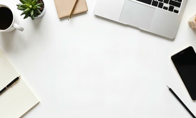Minimalist office desk setup, with stationery, coffee cup, laptop, and smartphone framing an empty workspace in the middle.