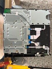 Close-up view of an open electronic device showing its internal circuit board and components. This...