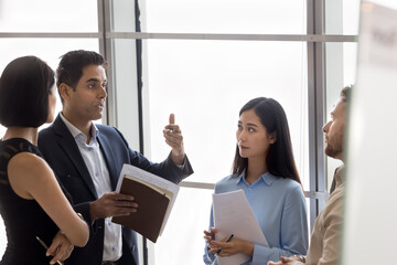 Informal meeting brings insight. Inspired mature man business professional expert executive share opinion idea plan during casual conversation with multicultural coworkers on break time in work office