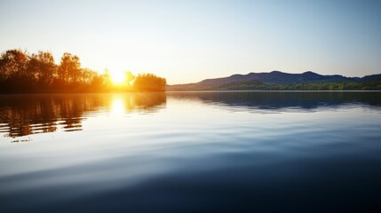 Fototapeta premium Tranquil Morning at Serene Lake with Gentle Ripples and Golden Sunlight Reflections at Dawn