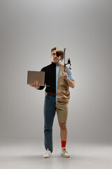 Composite image. Man in turtleneck with laptop on one side and fishing vest with rod on other,...