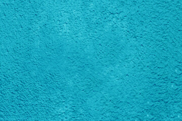 Old plaster painted with blue paint close-up.