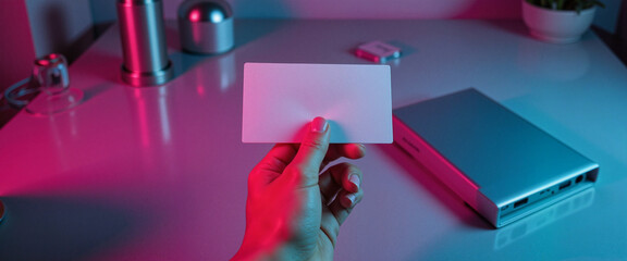 Elegant hand holding blank business card mockup indoors, branding showcase