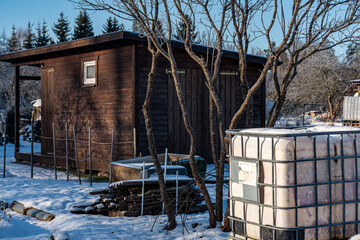 wonderful winter day, trees and grass covered with frost, small wooden sheds in the garden