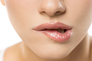 Naklejka premium Sensual, soft lips with a provocative bite, revealing a glossy, natural texture that hints at subtle allure and feminine mystique