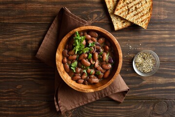 Baked beans in bowl on wooden table