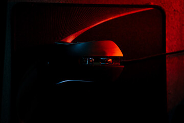 Illuminated gaming mouse on a vibrant desk mat in a dimly lit work environment