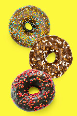 Flying levitating floating sweet sugar glazed doughnuts,tasty donuts in air on yellow background.Creative dessert food.healthy unhealthy nutrition.