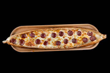 Turkish pide dish with slices of pepperoni and cheese. Turkish traditional pita. (pide with pepperoni) on wood service. Turkish name; Sucuklu pide. Isolated on black background.