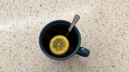 a cup of black hot tea with lemon