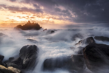 last rays of sun at sunset on Meñakoz beach, in Sopelana and Barrika, with the silky water between the rocks