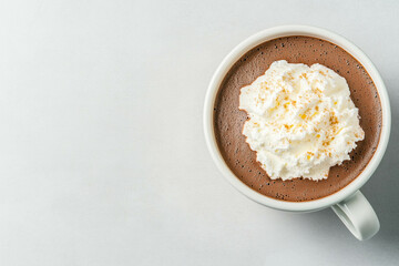 Cup of hot chocolate with whipped cream on light background