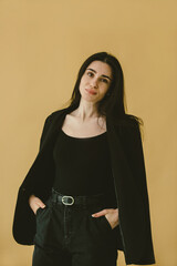 Confident Woman in Stylish Black Office Attire Against Minimalistic Beige Background