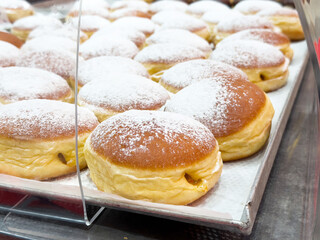 Delicious powdered sugar doughnuts displayed on a bakery tray