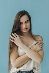 Naklejka premium Young Woman with Long Hair Against a Light Blue Background