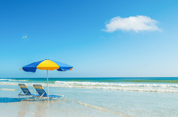 Two beach chairs and a parasol on the sand