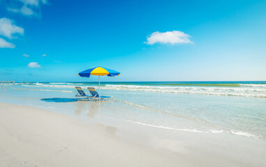 Two beach chairs and a colorful parasol on the sand