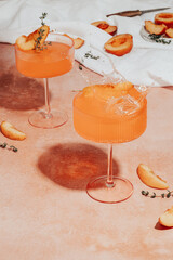 Ice cube falling into a peach cocktail