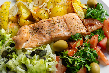 Baked red fish with vegetables and potatoes. Healthy food.