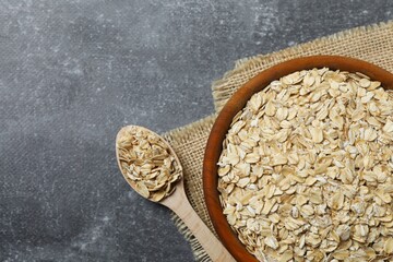 Composition with oatmeal flakes on gray background. Cooking breakfast