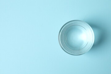 Transparent glass with water on blue background. Drinking clear water in the morning for health