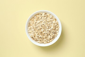 Composition with oatteal flakes on beige back ground. Cooking breakfast