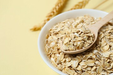 Composition with oatteal flakes on beige back ground. Cooking breakfast