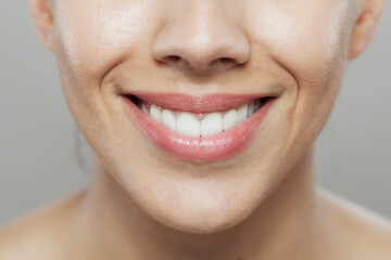 Obraz premium Close-up of a smiling woman showing healthy teeth and lips