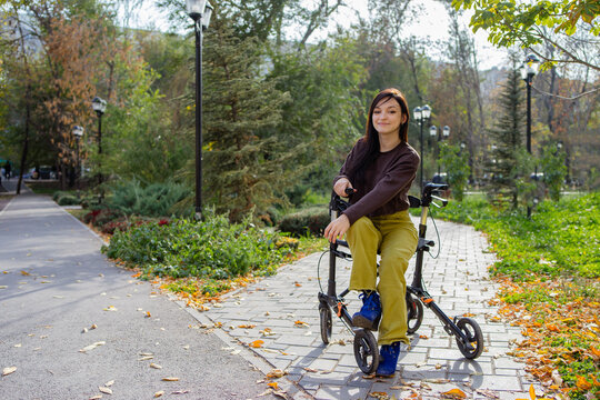 A woman with cerebral palsy with a walker enjoying a sunny day in park