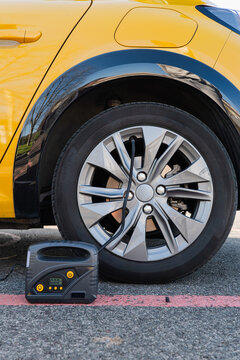 Electric car wheel with portable tire inflator on an urban street