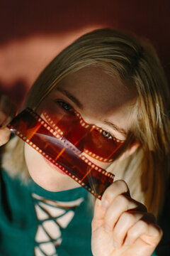 Teen Holding Film Negative in Artistic Portrait