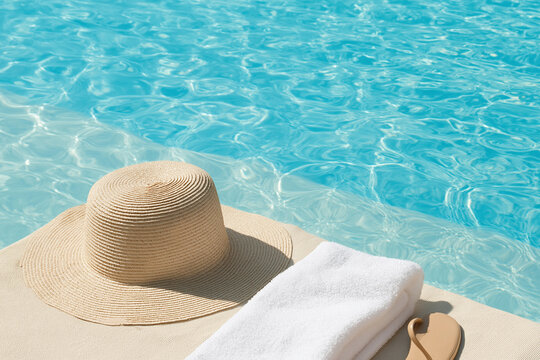Relaxing by the pool with a sun hat and towel on a sunny day
