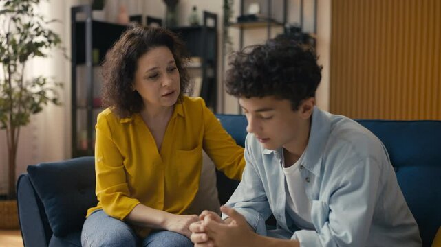 Caring mother comforting and supporting her upset teenage son, parental love