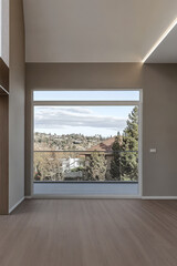 Modern interior showcasing large window with scenic view of trees and houses in daylight