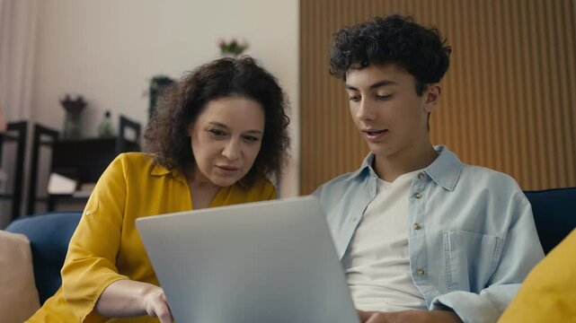 Adolescent son and his mother choosing a college online, family bonding time