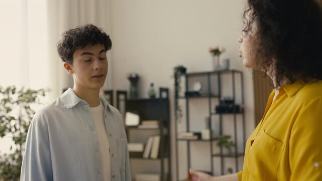 Displeased mother scolding her adolescent son for rebellious behavior at home